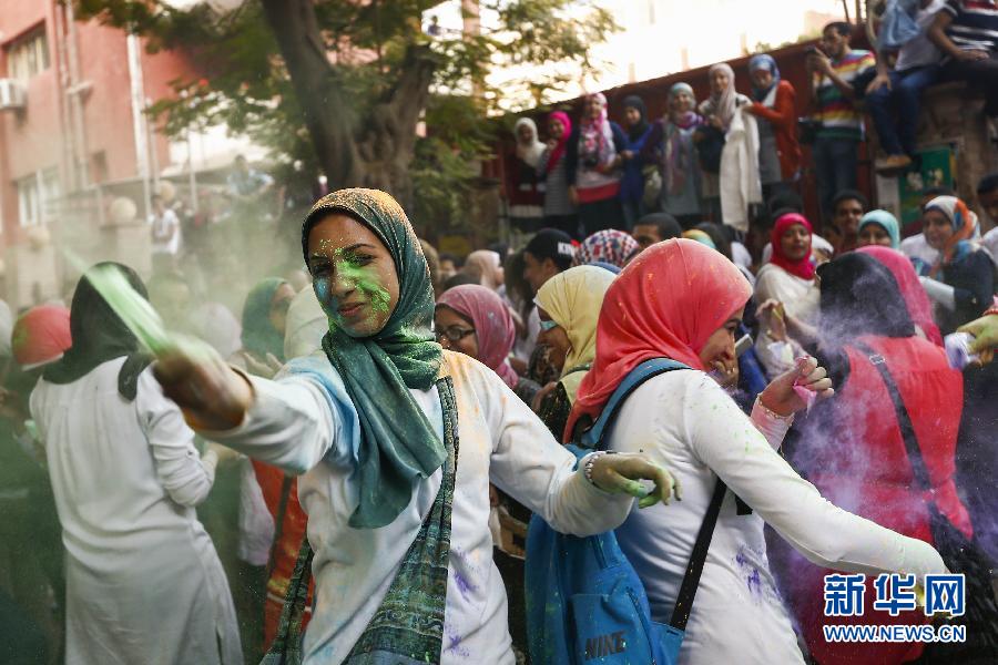 10月16日，在埃及首都開(kāi)羅，一名女青年在“彩色跑”活動(dòng)中拋撒彩色粉末。