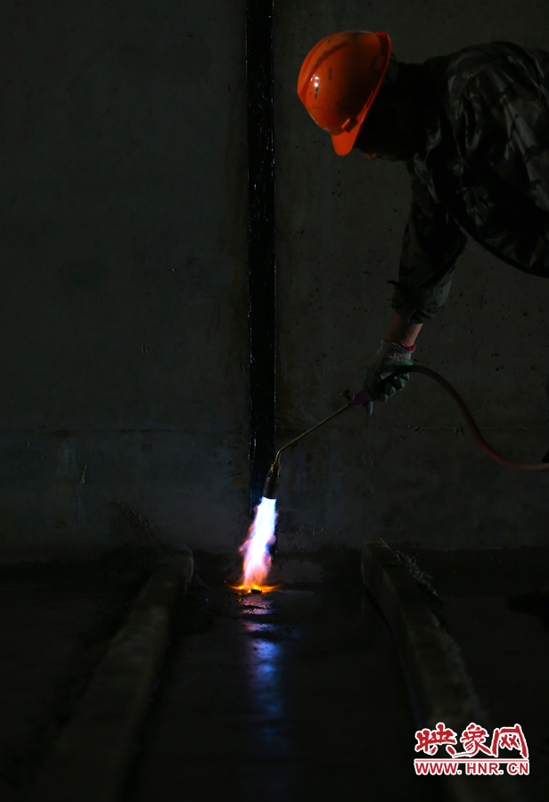 工人師傅用噴槍烘干地面，便于做防水處理