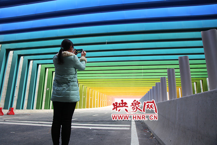 一女孩拿出手機(jī)拍照。