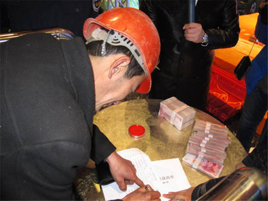 農(nóng)民工在現(xiàn)場領(lǐng)取工資。