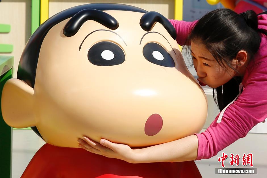 4月22日，游客與蠟筆小新合影。“蠟筆小新25周年紀(jì)念特展”日前在北京開展，吸引了不少市民游客。