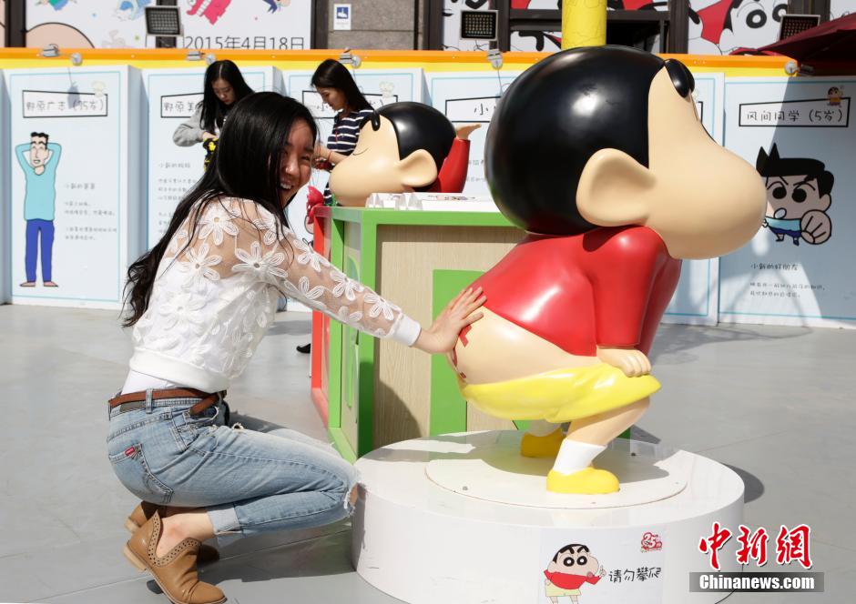 4月22日，游客與蠟筆小新合影?！跋灩P小新25周年紀(jì)念特展”日前在北京開展，吸引了不少市民游客。