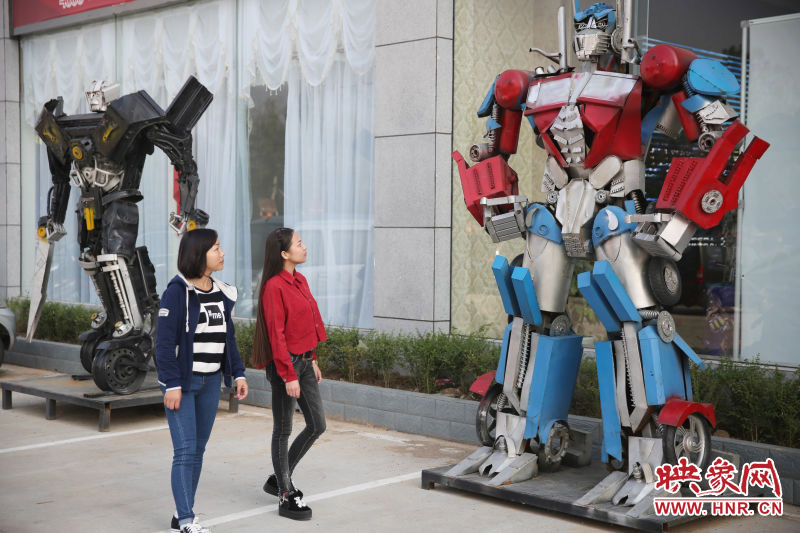 10月14日，市民在參觀河南省平頂山市寶豐縣一家企業(yè)門前的“變形金剛”。