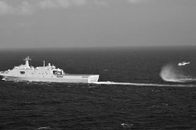 11日，抵達(dá)馬航飛機(jī)失聯(lián)海區(qū)的海軍井岡山艦與艦載直升機(jī)協(xié)同展開立體搜救行動。新華社發(fā)