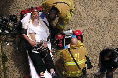 2日，救援人員在美國紐約地鐵事故車輛內(nèi)緊急疏散一名受傷乘客。圖/CFP