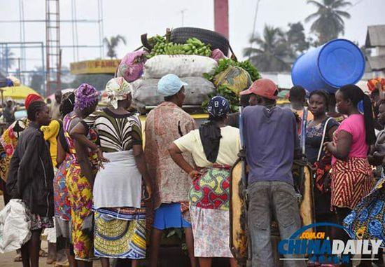 當?shù)貢r間2014年8月14日，利比里亞蒙羅維亞，市場里的商人們圍著一輛汽車。