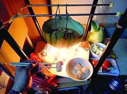 兩張椅子被面對(duì)面疊在一起，穿了兩根線的西瓜皮就懸空在椅腳中間，下面有蠟燭加熱，這就是西瓜火鍋。