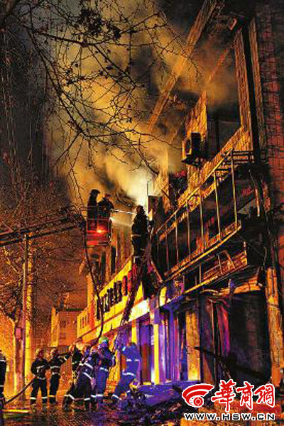 昨日22時(shí)10分，西安市豐慶路南小巷南口，消防官兵架梯子登上二樓施救 本組圖片由本報(bào)記者 閆文青 攝