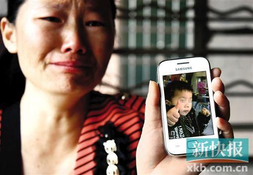 男童的舅媽拿著小益的照片,悲痛欲絕。 新快報記者 畢志毅 攝