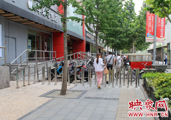 圖中道路左側(cè)的無障礙通道被鋼管隔離,右側(cè)的盲道也被侵占。