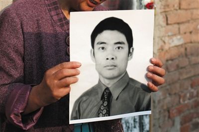 5月19日，朝陽(yáng)北路，母親捧著張東文的遺像。新京報(bào)記者 侯少卿 攝