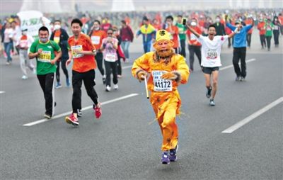 長安街，一名打扮成孫悟空的參賽者在北馬隊(duì)伍里飛奔。 本版攝影/新京報(bào)記者 吳江 李飛 王嘉寧 吳江