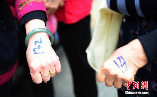 圖為10月28日，在江西九江市一家羊絨皮草服裝服飾博覽會(huì)現(xiàn)場(chǎng)，老人們正在頂著寒風(fēng)排隊(duì)等待領(lǐng)取10元代金劵。