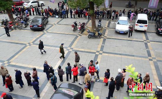圖為10月28日，在江西九江市一家羊絨皮草服裝服飾博覽會(huì)現(xiàn)場(chǎng)，老人們正在頂著寒風(fēng)排隊(duì)等待領(lǐng)取10元代金劵。
