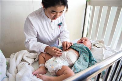 昨日，北京兒童醫(yī)院，護士為即將出院的被扎鋼針女嬰檢查傷口恢復情況。記者 高瑋 攝