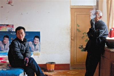 父親抽煙，兒子不語。逃跑的越南新娘，給袁迎賓父子帶來的是失落。新京報記者 周崗峰 攝