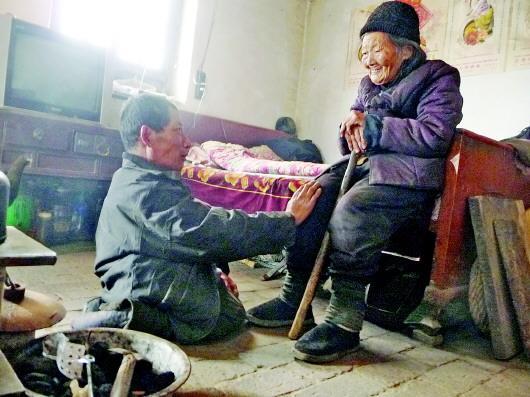 52歲的劉蘭山每天靠爬行照顧90歲的老母親。孫國祥 攝