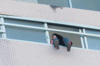 28樓的窗臺上坐著一名女子，其兩條腿耷拉在室外，不停地?cái)[動。