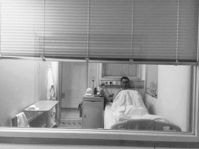 楊杰在醫(yī)院隔離病房中，沖記者揮了揮手。