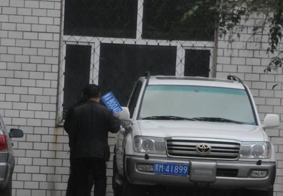 程父與程的“司機(jī)”在居住小區(qū)內(nèi)將黑AB0040車牌更換為黑M41899車牌，倆車牌號均為空號