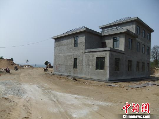 鴨河水庫庫區(qū)邊的新建別墅，一面墻上寫著“拆”，另一邊在加緊施工。吳揚　攝