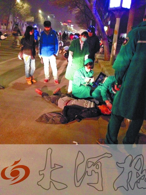 醉漢躺在地上，醫(yī)護(hù)人員對(duì)其進(jìn)行檢查。